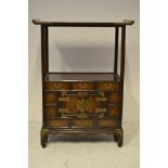 A 20th Century Korean elm side cabinet, altar style top, brass mounted cupboards and drawers below -