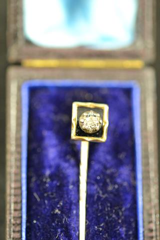 A yellow metal stick pin, mounted with a diamond bordered with black enamel in square setting - L4.