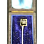 A yellow metal stick pin, mounted with a diamond bordered with black enamel in square setting - L4.