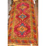 A Middle Eastern purple ground rug, three diamond design to centre, stylised animals to border -