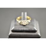 An 18ct gold diamond ring with central diamond and diamond shoulders, central diamond