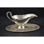 A Mexican .925 sterling silver sauce boat and stand, scroll handle and scroll edge - approx weight