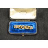 A yellow metal five stone interlinked bar brooch, three sapphires and two diamonds - L4.5cm, cased