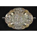 A continental embossed silver two handled sweetmeat dish with fruit and figure decoration, London