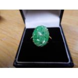 A 9ct white gold ring mounted with pierced and carved jade - size N, approx gross weight 2.1g.