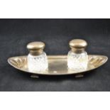 A late Victorian boat shaped embossed silver monogrammed inkwell, two glass ink bottles, London