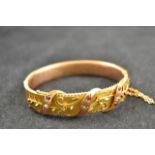 A 9ct gold bangle decorated with diamonds and rubies, floral filigree work, maker NBs - approx gross