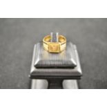An 18ct gold signet ring with central gypsy set diamond and Greek key design to shoulders - size