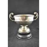 An early 20th Century two handled silver trophy bowl, uninscribed, ebonised pedestal, London