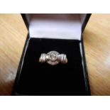 An 18ct white gold ring with central diamond surrounded by six smaller diamonds in Art Deco style