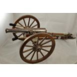 A mid/late 20th century model of a cannon on carriage with twelve spoke metal rimmed wheels,