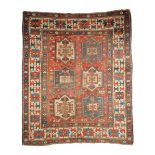 A SMALL VINTAGE CAUCASIAN RUG, with a red brick field centering blue, brick red and neutral