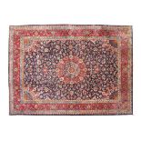 A SAROUK CARPET, MODERN, of rectangular form and centering a deep blue and Persian rose field,