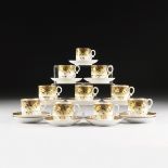 A SET OF TEN VICTORIAN PARCEL GILT AND POLYCHROME PAINTED GREEN GROUND PORCELAIN CUPS AND SAUCERS,