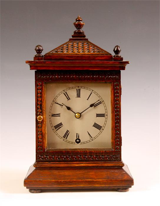 A late 19th Century carved Oak MANTEL CLOCK with sloping pediment and silvered sheet brass Roman