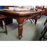 Victorian Oak Wind out table supported on turned fluted legs and caster feet, with 2 extra leaves