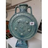 Large Turquoise Pottery Moon flask decorated with foliate borders and Egyptian masks, two handles