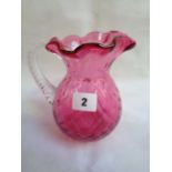 Good Quality Cranberry Glass water jug of ovoid form, cruciform impressed decoration with mounted