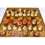 A 19th Century Staunton ivory and red stained ivory chess set together with a rosewood chess board