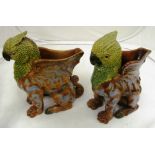 A pair of majolica style vases in the form of winged griffins with glass eyes and blue decoration (