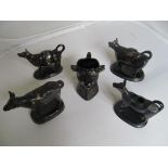 Four black cow creamers and a head jug creamer.