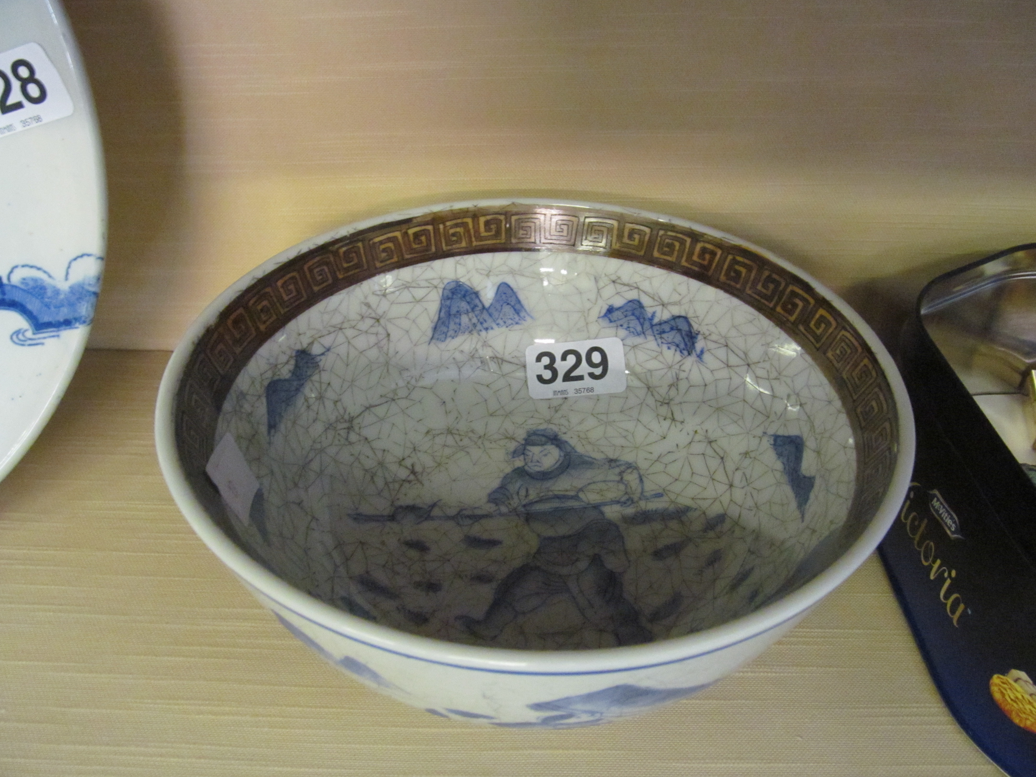 A Chinese bowl with brown greek key border and scene of huntsman in blue