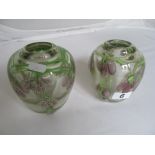 A pair of heavy glass vases with pink floral design.