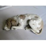 A Lladro hound lying down.