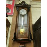 A walnut cased regulator style clock with white enamel dial and oval cresting