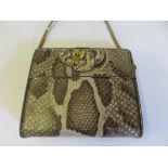 A novelty Huntley & Palmers biscuit tin in the form of a snakeskin handbag