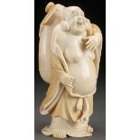 A FINE JAPANESE CARVED IVORY OKIMONO OF A HOTEI (LAUGHING BUDDHA), MEIJI PERIOD. Fully carved in