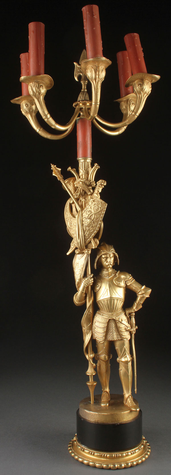 A FRENCH GILT BRONZE GOTHIC REVIVAL FIGURAL CANDELABRA OF A PALACE GUARD, 19TH CENTURY. Dressed in