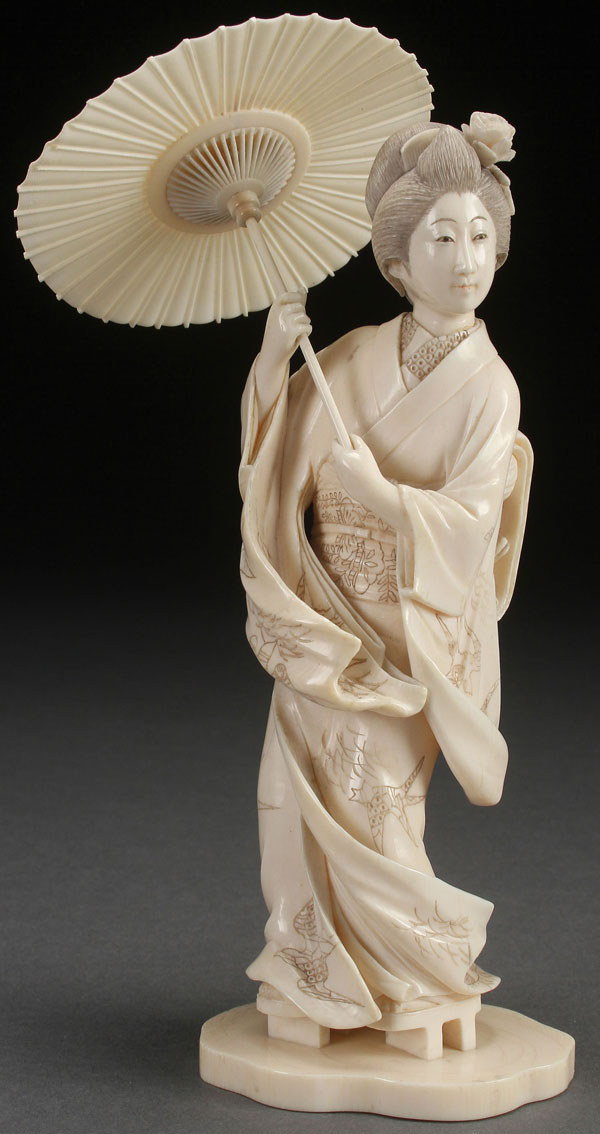 A VERY FINE JAPANESE CARVED IVORY OKIMONO OF A GEISHA, MEIJI PERIOD. Depicted with a windswept gown