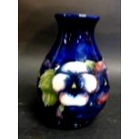 A Moorcroft Squat Vase, tube lined with pansies upon a blue ground, 15.