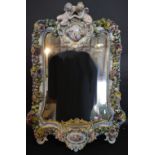 A Meissen Porcelain Large Wall Mirror with Putti Cresting above a reserve depicting exotic birds
