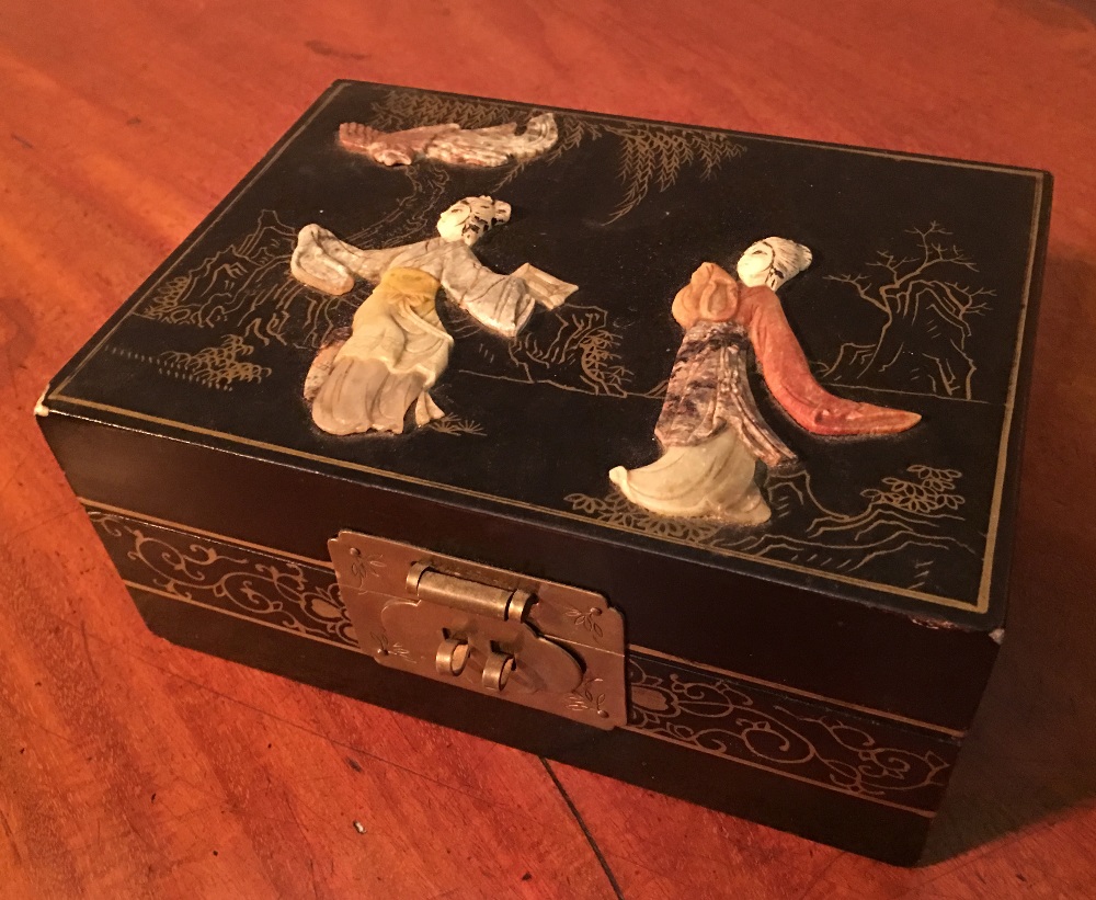 A Japanese Lacquered Hard Stone Jewellery Box decorated in relief with figures within a landscape,