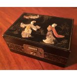 A Japanese Lacquered Hard Stone Jewellery Box decorated in relief with figures within a landscape,