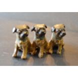 A Patinated Bronze Group in the form of Three Dogs,