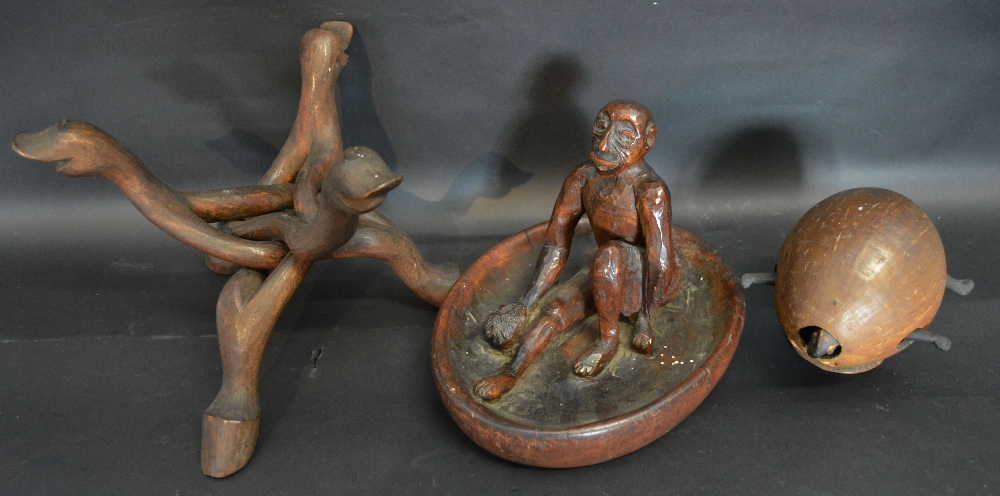 An African Carved Wooden Figure of a Man upon a base together with a carved wooden tripod in the