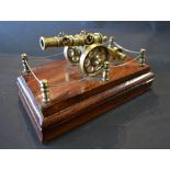 A Brass Model in the form of a Canon, upon wooden plinth,