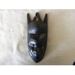 An African Carved wooded face of that very typical hard, dark wood. Measures roughly 10" x 4" a