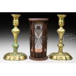 PAIR OF QUEEN ANNE BRASS CANDLESTICKS AND ANTIQUE GLASS AND WOOD HOUR GLASS. Lot includes a pair