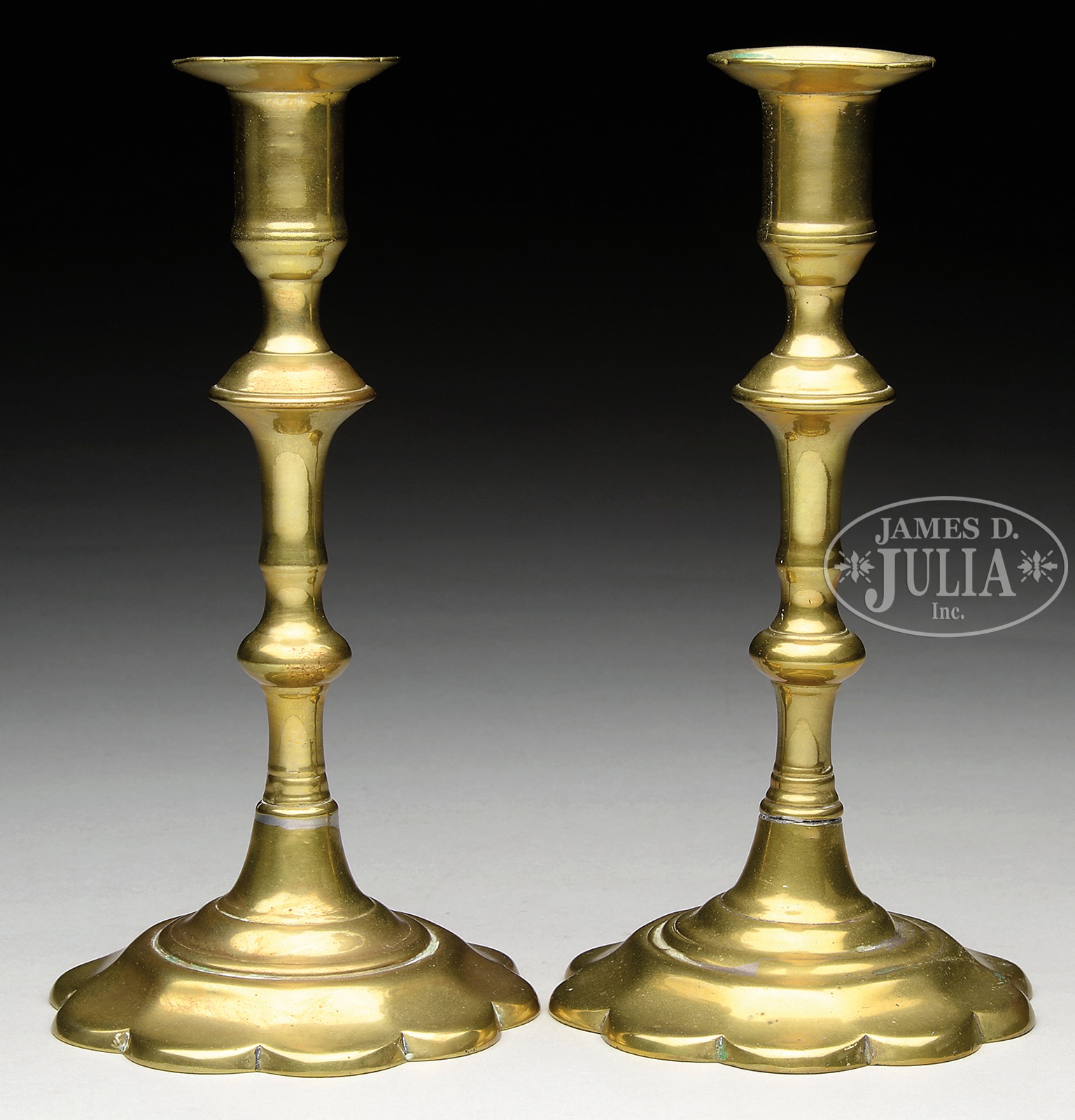 PAIR OF PETAL BASE QUEEN ANNE BRASS CANDLESTICKS. Turned shaft ending in cylindrical candlecup