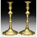 PAIR OF PETAL BASE QUEEN ANNE BRASS CANDLESTICKS. Turned shaft ending in cylindrical candlecup