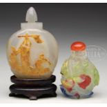TWO CARVED SNUFF BOTTLES. China, 20th century. The first a carved agate bottle with a relief