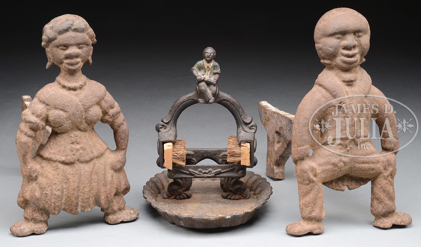 PAIR OF FIGURAL ANDIRONS AND BOOTSCRAPER. The andirons in the form of a black couple with hands on