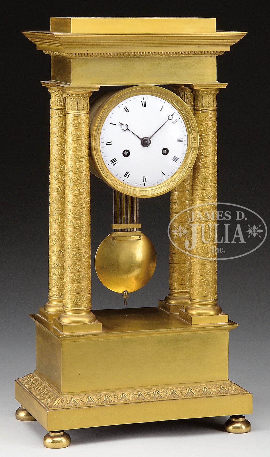 FRENCH EMPIRE STYLE GILT BRONZE MANTEL CLOCK. White enameled dial with two key holes centered on