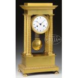 FRENCH EMPIRE STYLE GILT BRONZE MANTEL CLOCK. White enameled dial with two key holes centered on