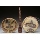 TWO NORTHWEST DRUM FACES AND A SMALL TOTEM POLE.