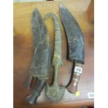 WEAPONS, 2 leather sheathed kukris, also brass cased mid Eastern curved blade dagger